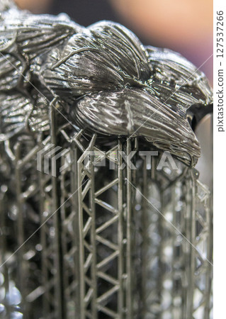 An object printed on a 3D printer from hardened rubber close-up. Model black color created on a 3D printer from hardened rubber under influence of ultraviolet light. SLA 3D printing. Stereolithography An object printed on a 3D printer from hardened rubber close-up. Model black color created on a 3D printer from hardened rubber under influence of ultraviolet light. SLA 3D printing. Stereolithography 127537266