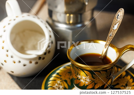 Elegant coffee moment with fine china and a traditional brewer in a cozy setting Elegant coffee moment with fine china and a traditional brewer in a cozy setting 127537525