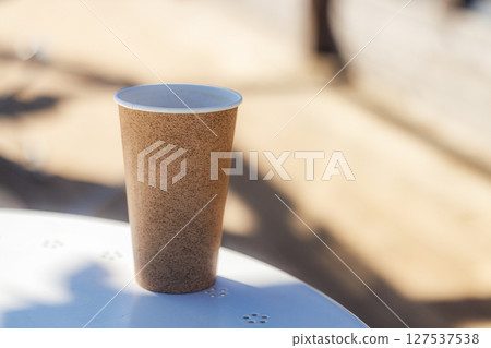 Enjoying a warm cup of coffee at an outdoor cafe on a sunny afternoon with a blurred background 127537538