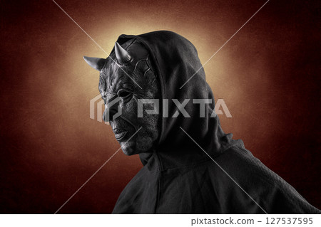 Portrait of a bad devil with horns on head over dark fiery background 127537595