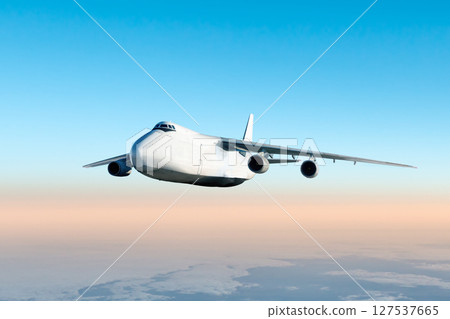 White wide body transport freight aircraft fly in the air above the clouds 127537665