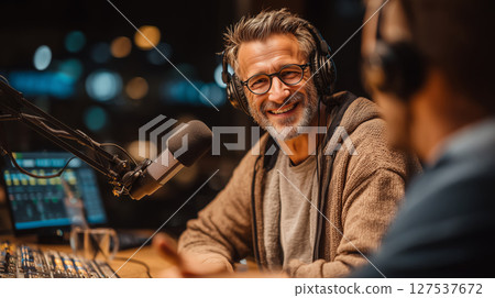 Smiling man engages with presenter during live discussion at studio 127537672