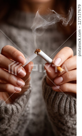 Woman decisively breaks a cigarette in a moment of determination 127537679