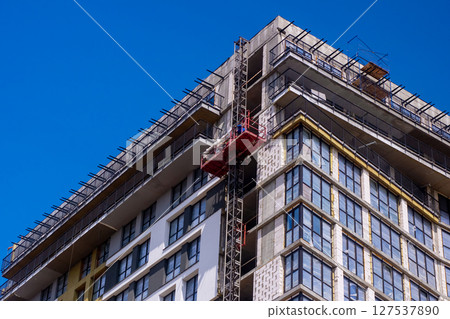 A building under construction with a blue sky behind it 127537890