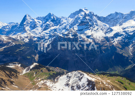 View of three famous Swiss mountain peaks Eiger, Monch and Jungfrau in the Bernese Oberland in Switzerland View of three famous Swiss mountain peaks Eiger, Monch and Jungfrau in the Bernese Oberland in Switzerland 127538092