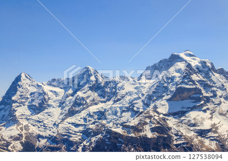View of three famous Swiss mountain peaks Eiger, Monch and Jungfrau in the Bernese Oberland in Switzerland 127538094