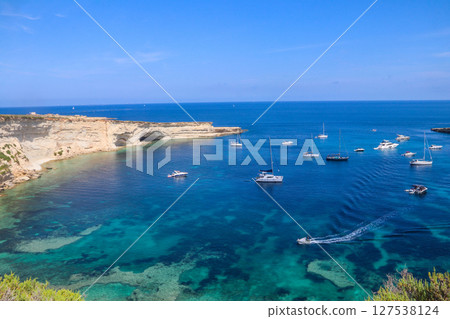 Beautiful coastal view of Delimara peninsula with rocks and turquoise sea with yachts on Malta 127538124