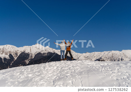 Couple Winter Mountains Triumph: Joyful Celebration Snowy Peak, Sunny Day Couple Winter Mountains Triumph: Joyful Celebration Snowy Peak, Sunny Day 127538262