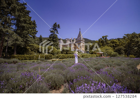 A woman is walking through a field of lavender 127538284