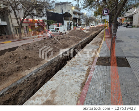 Cordoba, Argentina - May 08, 2025: Construction work. Laying underground utilities in city center. Trench and soil dumps for laying utilities. Cordoba, Argentina - May 08, 2025: Construction work. Laying underground utilities in city center. Trench and soil dumps for laying utilities. 127539428