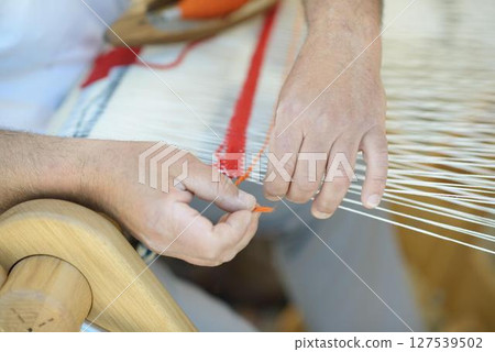 Orange Yarn Pattern on Handloom with White Warp Threads 127539502