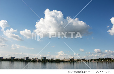 Panoramic view of the left bank of the Dnieper River. Dnieper. Ukraine. Reflection of the sky with clouds on the water surface. Panoramic view of the left bank of the Dnieper River. Dnieper. Ukraine. Reflection of the sky with clouds on the water surface. 127539740