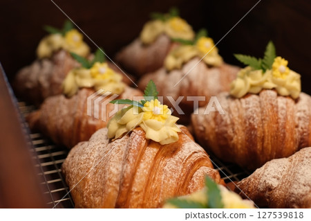 croissants with durian and creamy yellow cream Yummy freshly croissant, sliced almonds, with custard filling cut, close up 127539818