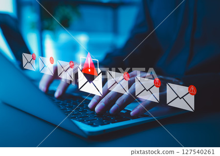 Email Security Threat Notification and Spam Warning Concept. A person using laptop with icons of mail envelopes showing red warning symbols represents potential email security threats and spam alerts. 127540261