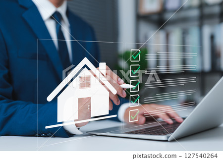 Real Estate Property Inspection Checklist Concept. Business professional using laptop with house icon and checklist interface, symbolizing property evaluation analysis or real estate inspection. 127540264