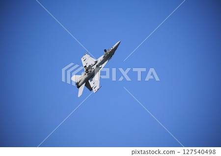 Hornet fighter jet performing acrobatic flying 127540498