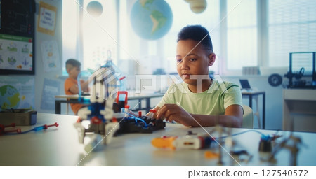 Primary School: Smart Boy Studying Robotic Arm Model During Science Lesson 127540572