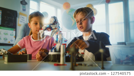 Primary School Children Sitting at Table, Studying Robotic Arm Model Primary School Children Sitting at Table, Studying Robotic Arm Model 127540575