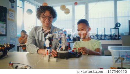 Elementary School Student Studying Model of Robotic Arm. Young Teacher Educating Smart Boy 127540630