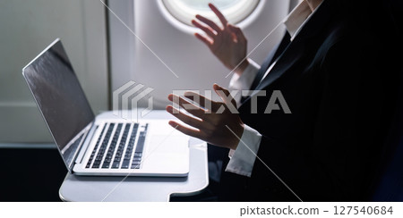 businesswoman flying and working in an airplane in first class, businesswoman sitting inside an airplane using laptop businesswoman flying and working in an airplane in first class, businesswoman sitting inside an airplane using laptop 127540684