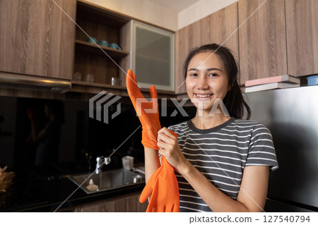 Female housekeeper smile and wearing glove, preparing to cleaning home Female housekeeper smile and wearing glove, preparing to cleaning home 127540794