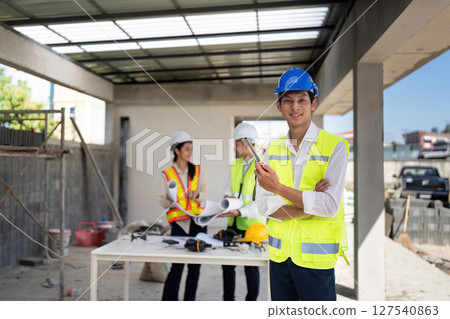 electrical engineer stand with walkie-talkie in construction building and engineer colleagues are working in the background 127540863