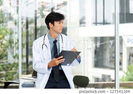 Doctor in Consultation. Physician reviewing patient information in modern clinic. 127541104