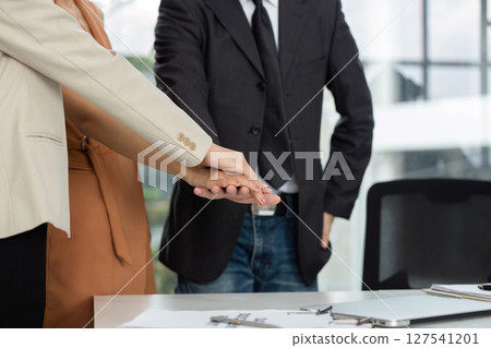 Team Collaboration and Unity. Professionals joining hands in a business agreement. 127541201