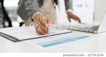Data Entry and Management. Business professional organizing financial reports on desk. 127541244