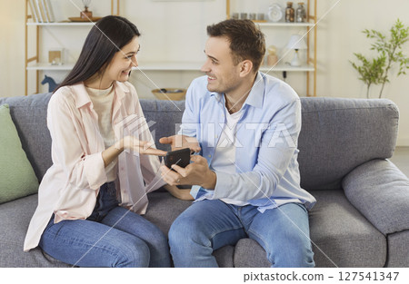 Happy boyfriend presenting engagement ring to girlfriend, making marriage proposal 127541347
