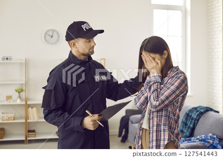 Police officer calming down a scared, crying woman, the victim of a house burglary Police officer calming down a scared, crying woman, the victim of a house burglary 127541443