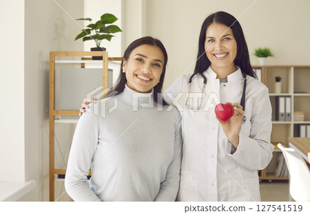 Portrait of two happy healthy women, cardiologist and her patient, with red heart 127541519