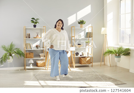 Portrait of a fat plus size brunette woman standing at home and smiling. Portrait of a fat plus size brunette woman standing at home and smiling. 127541604