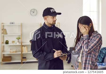 Weeping woman talking to police officer after breaking into house 127541605