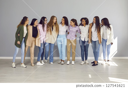 Happy cheerfull young diverse group of women friends or coworkers standing on grey background. 127541621