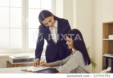 Businesswoman signing contract at business meeting in office Businesswoman signing contract at business meeting in office 127541791