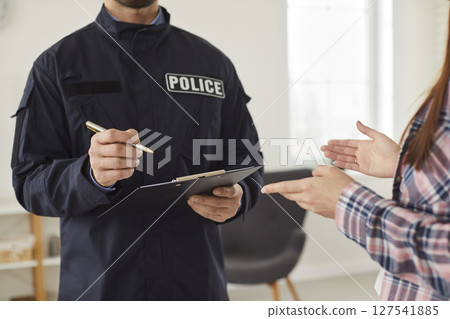 Policeman interrogating woman or witness regarding police investigation Policeman interrogating woman or witness regarding police investigation 127541885