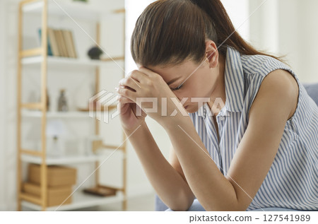 Woman suffers from migraines, stress and depression at work due to labor exploitation. 127541989