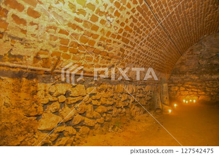 A view of old corridors lit by candles. Old cellar spaces lit by candles. The concept of romance and old times 127542475