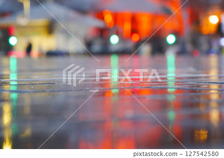 Captivating and Vibrant Reflections on Wet Pavement Under the Night Sky 127542580