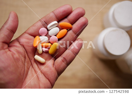 A Wide Variety of Different Dietary Supplements Held in One Hand A Wide Variety of Different Dietary Supplements Held in One Hand 127542598