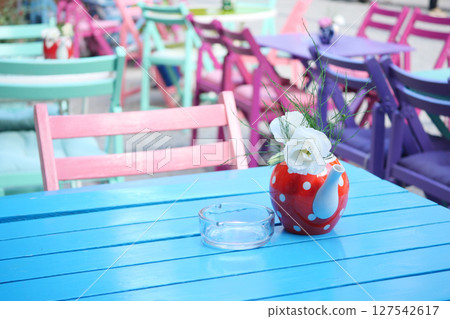 A Colorful Cafe Table Adorned with Beautiful Flowers and Vintage Decor A Colorful Cafe Table Adorned with Beautiful Flowers and Vintage Decor 127542617