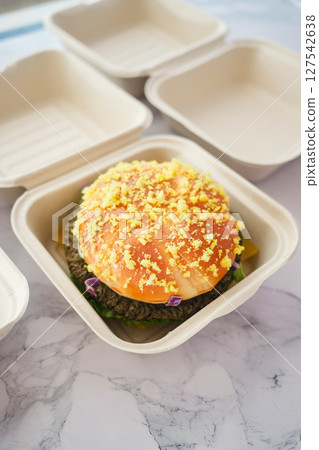 A Delicious Gourmet Burger with Cheddar Cheese in EcoFriendly Packaging 127542638