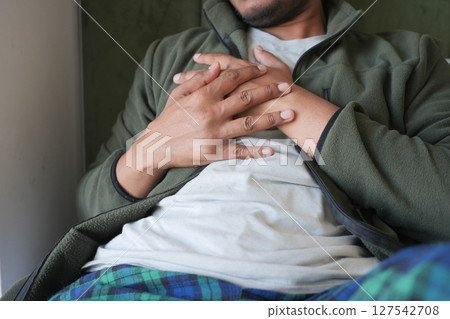 Man suffering chest pain laying on bed  127542708