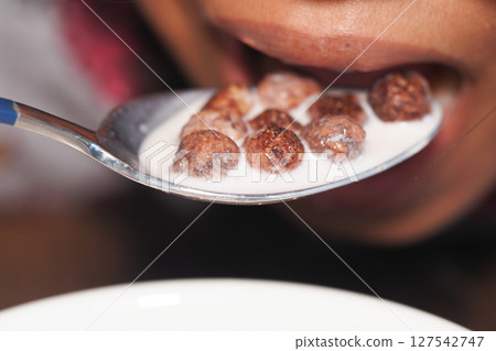 Spoonful of chocolate cereal with milk at breakfast Spoonful of chocolate cereal with milk at breakfast 127542747