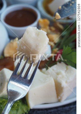 Delicious cheese served with fresh vegetables and sauces 127542804