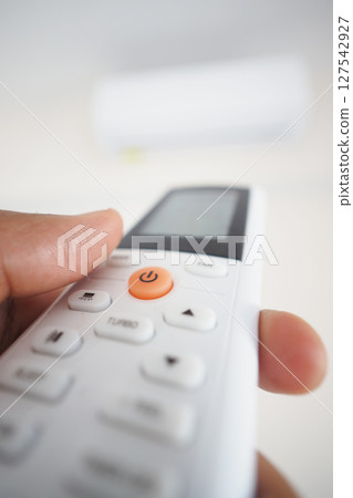 Air condition Remote control being held in a hand close up 127542927