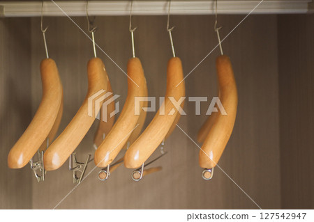 Wooden hangers arranged in a closet for storage Wooden hangers arranged in a closet for storage 127542947