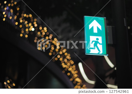 Emergency exit sign illuminated at night in urban area Emergency exit sign illuminated at night in urban area 127542961