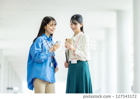 經營一部智能手機的女商人在辦公室 經營一部智能手機的女商人在辦公室 127543172